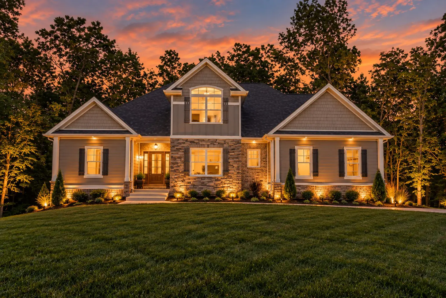 Beautiful house with illuminated landscaping at dusk