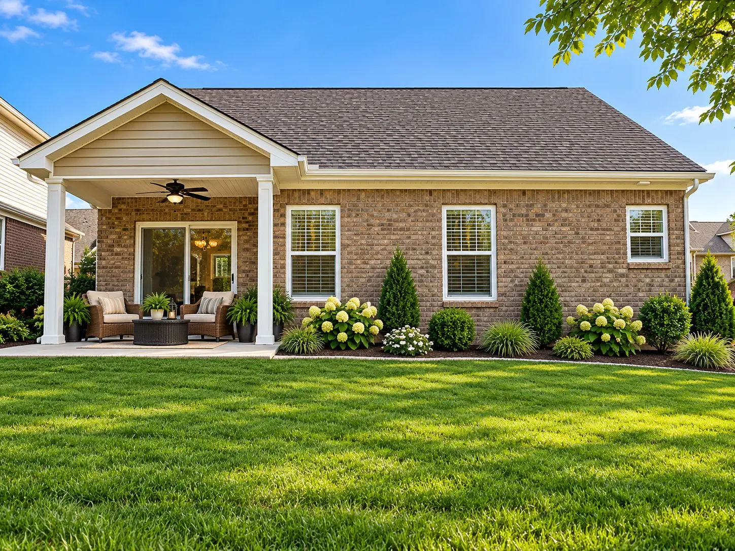 Brick house patio with green lawn and landscaping