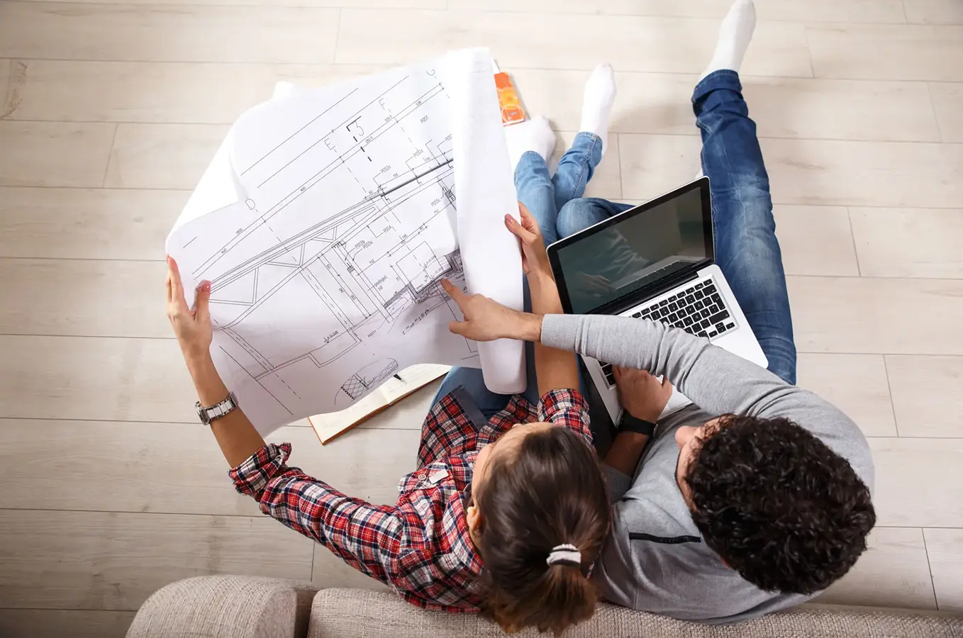 Overhead view, couple with plans and laptop